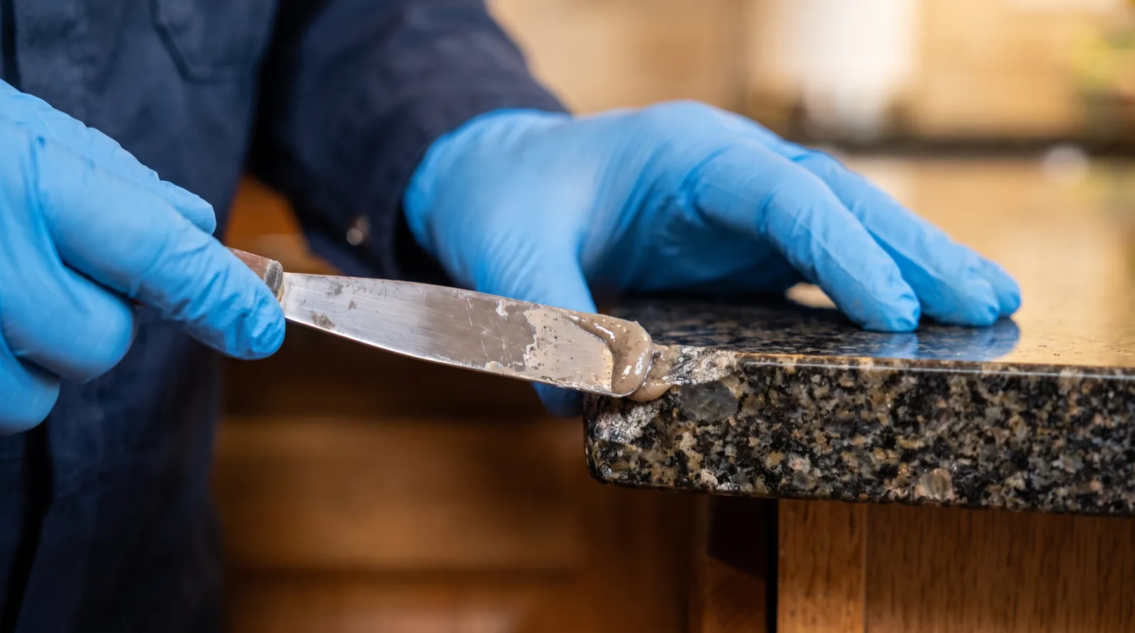 Color-matched epoxy chip repair on a granite countertop edge in Tampa