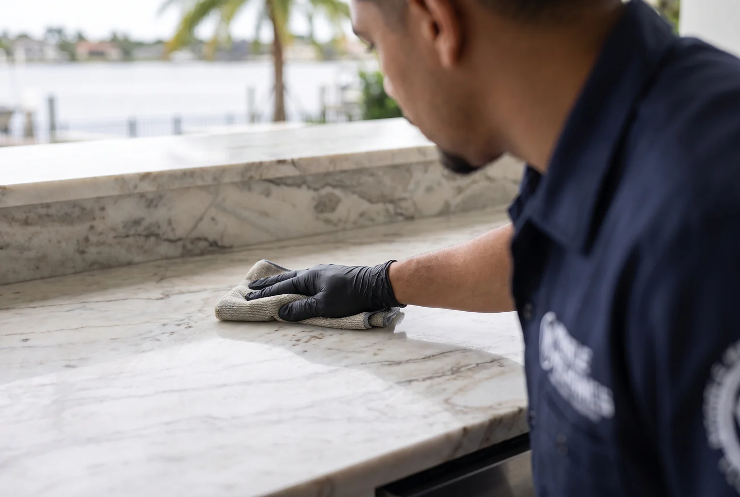 A Marble Mechanics technician hand-applying sealer to marble at a South Tampa waterfront property