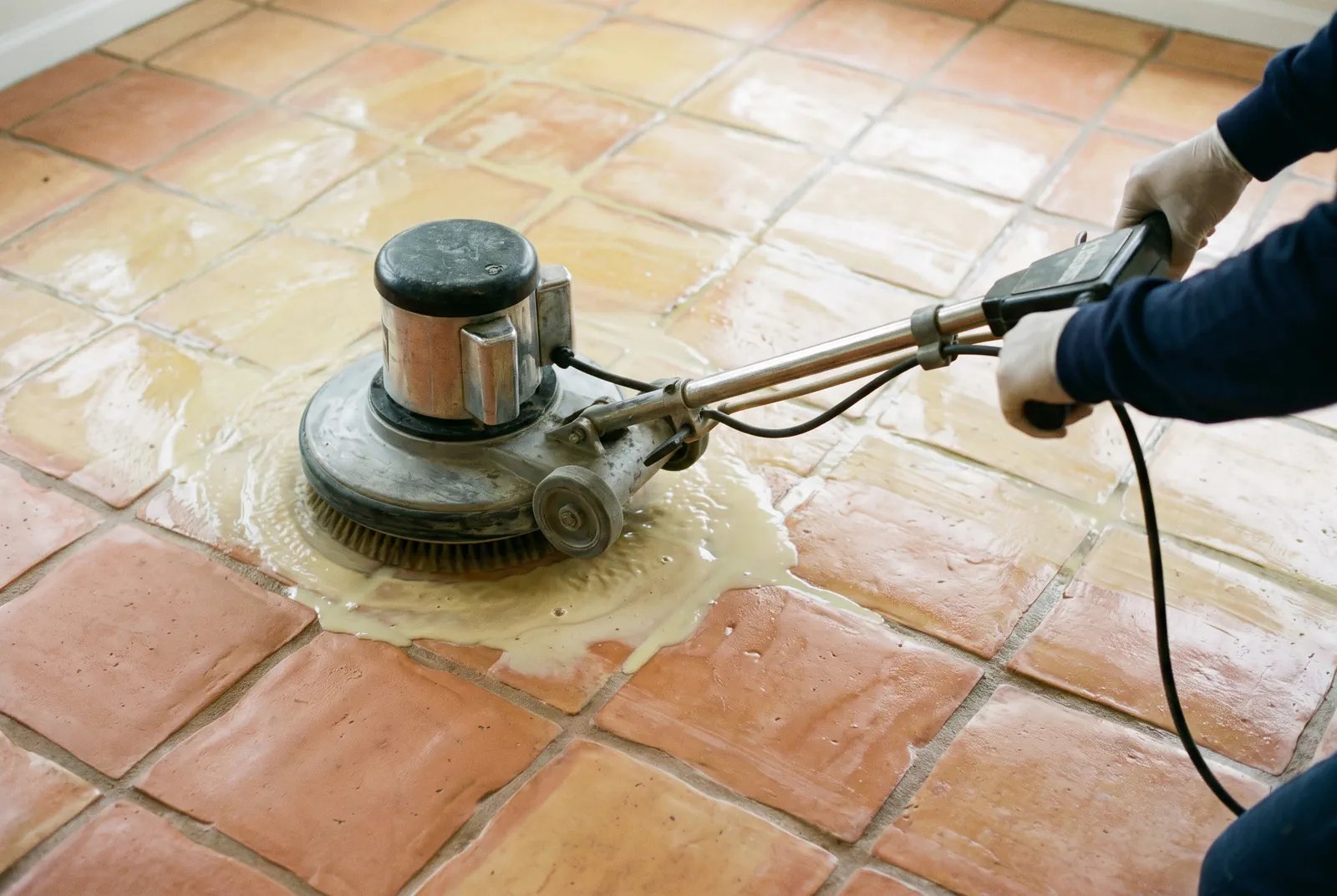 Stripping old sealer from a Saltillo tile floor with a rotary machine in Tampa