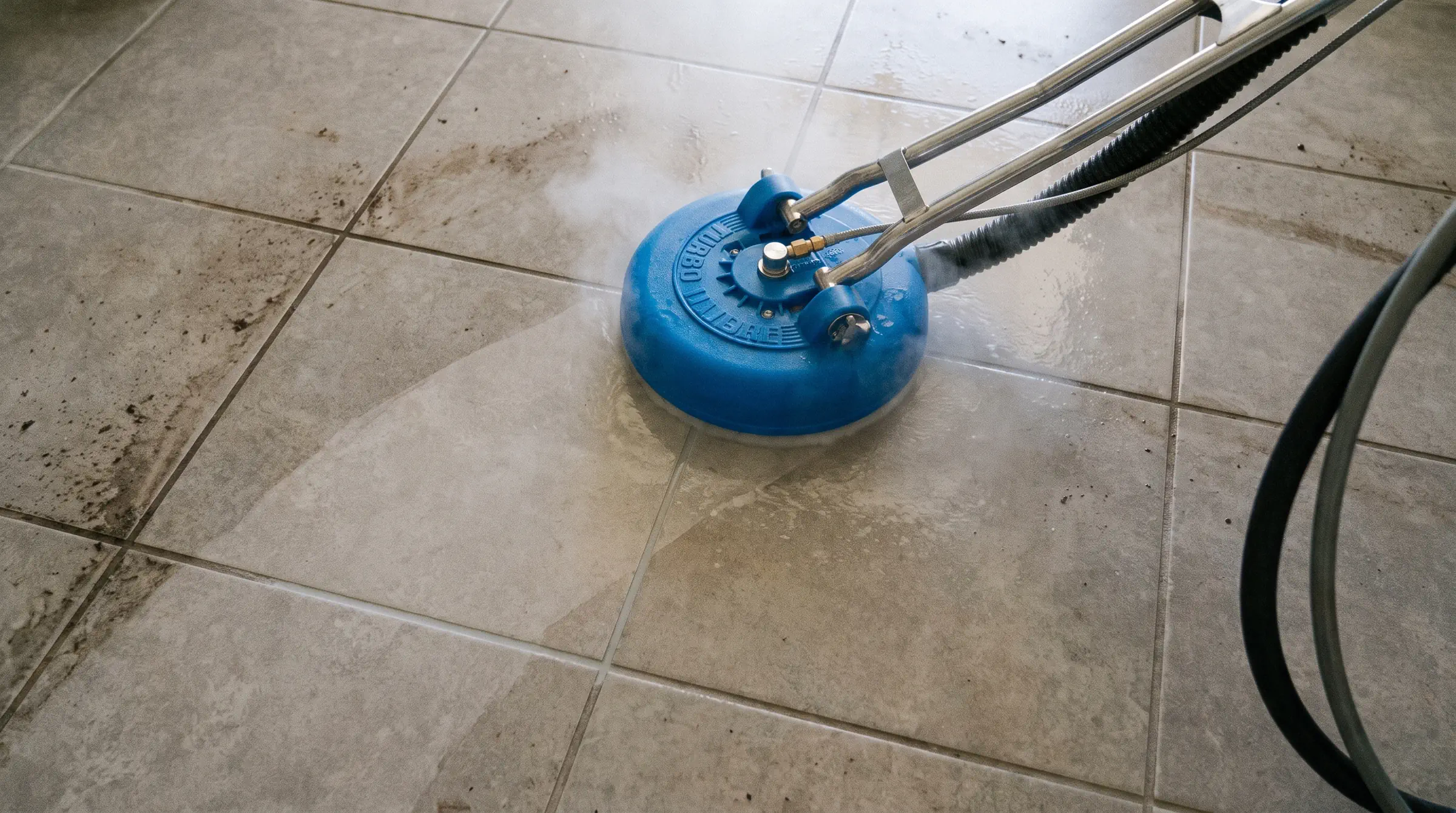 Tile and grout cleaning in Tampa: a spinner tool working across grouted tile with the cleaned half already showing